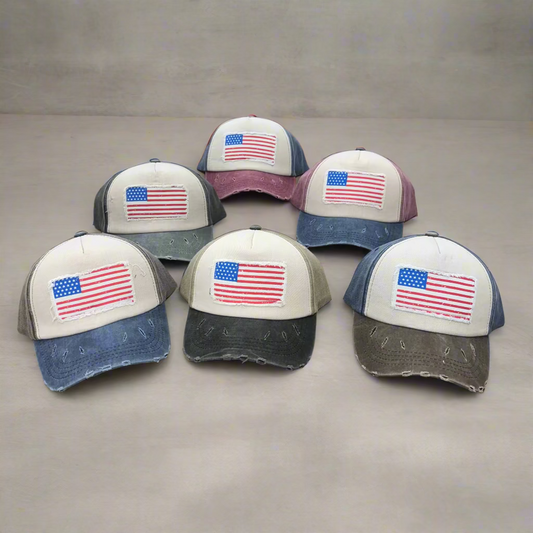 Six caps with American flag designs on a table.