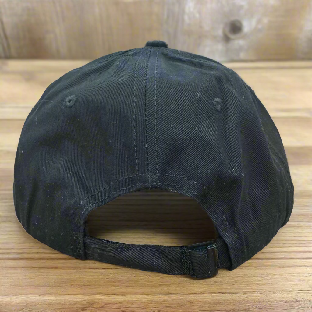 Black cap with a gold buckle on a wooden surface