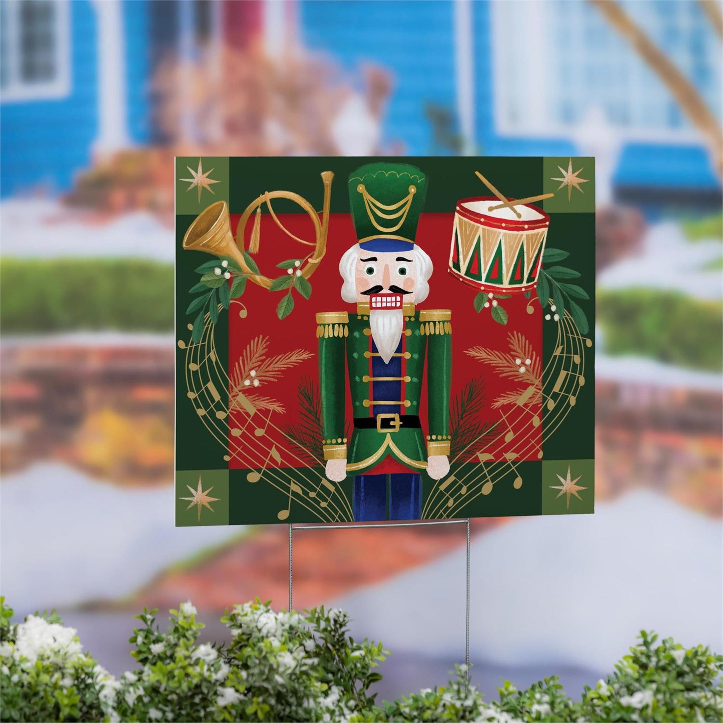 Decorative garden sign with a nutcracker design in front of a blurred outdoor background.