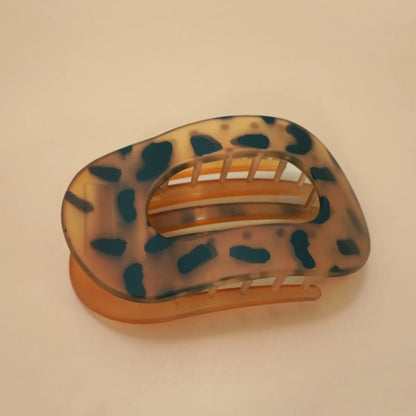 Tortoiseshell patterned hair clip on a beige background