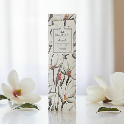 Greenleaf Magnolia slim sachet on a table with magnolia flowers.