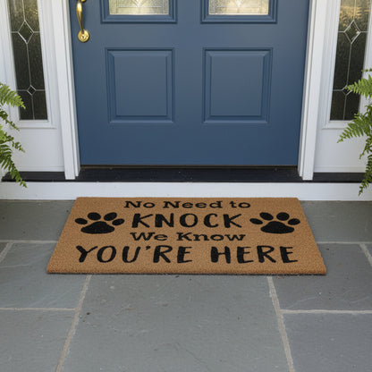 Doormat with text 'No Need to Knock We Know You're Here' and paw prints in front of a blue door.
