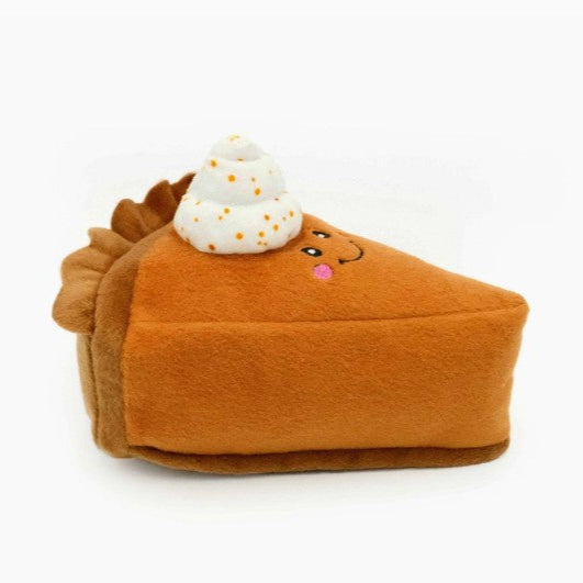 Plush toy shaped like a pumpkin pie with a smiling face on a white background