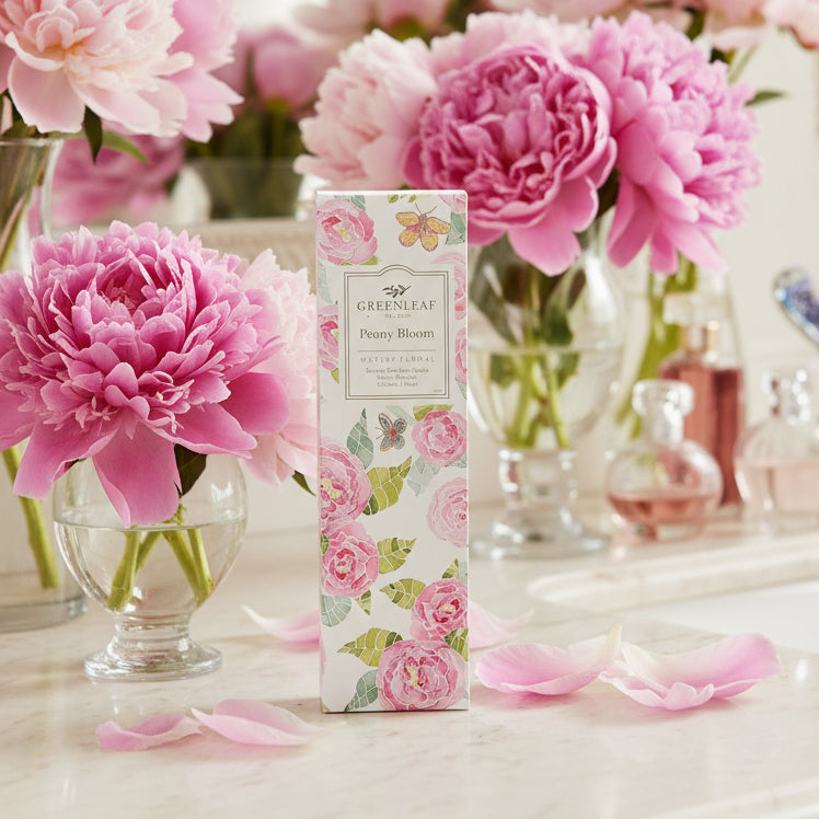 Greenleaf Peony Bloom slim sachet on a bathroom counter with vases of pink peonies.