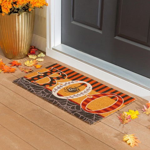 Decorative doormat with Halloween design on a wooden floor in front of a door.