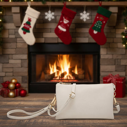 White handbag on a wooden surface with Christmas stockings and fireplace in the background