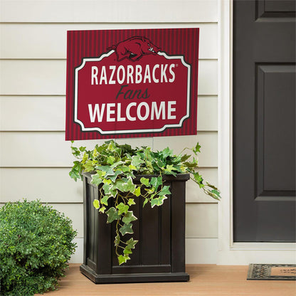 Decorative sign with 'Razorbacks Fans Welcome' text on a house exterior.