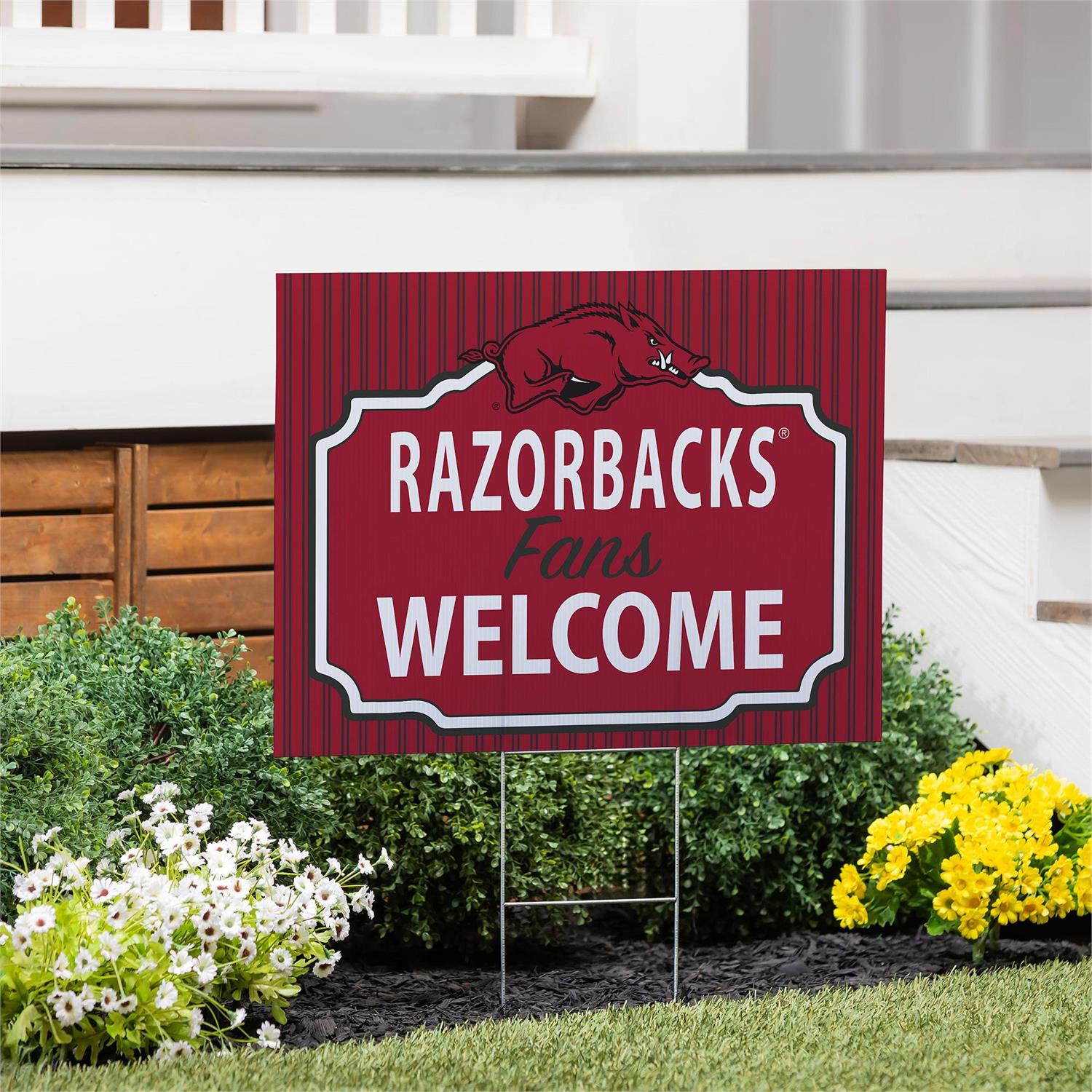 Garden sign with 'RAZORBACKS Fans WELCOME' text in a decorative frame on a lawn.