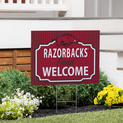 Garden sign with 'RAZORBACKS Fans WELCOME' text in a decorative frame on a lawn.