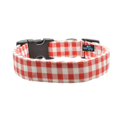 Red gingham dog collar with a black buckle on a white background