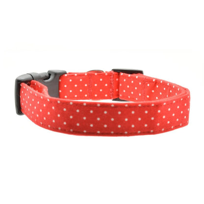 Red dog collar with white polka dots and a black buckle on a white background