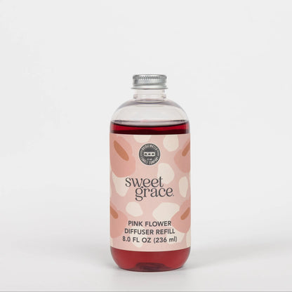 Bottle of 'sweet grace' pink flower diffuser refill on a white background