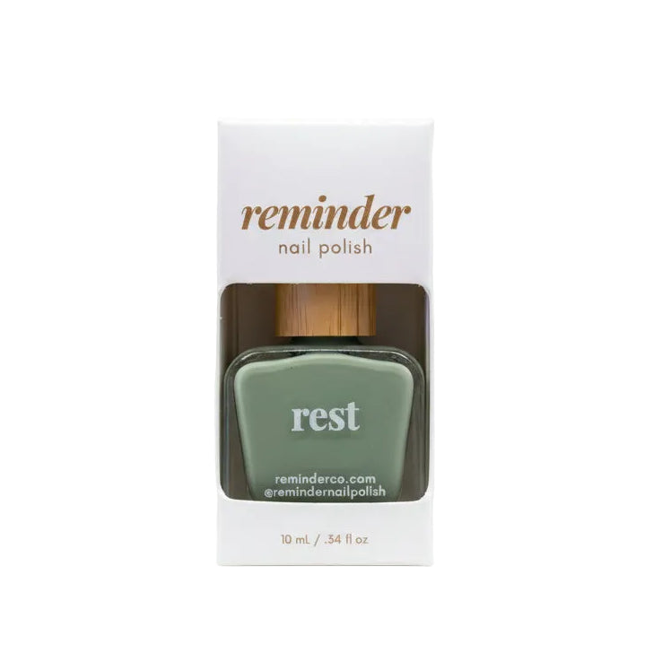 Reminder Nail Polish in Rest Sage Green in package on a white background.