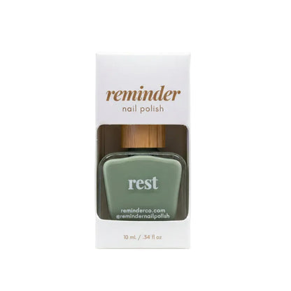 Reminder Nail Polish in Rest Sage Green in package on a white background.