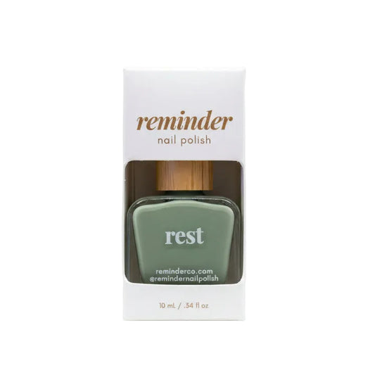 Reminder Nail Polish in Rest Sage Green in package on a white background.