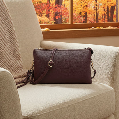 Brown crossbody bag on a white chair