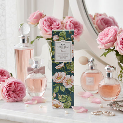Greenleaf Roses slim sachet on a vanity with bottles of perfume and vases of pink roses.
