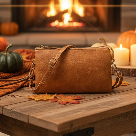 Brown  handbag on a wooden table with pumpkins and candles in the background