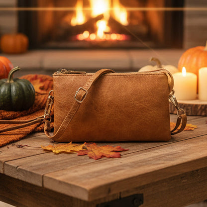 Brown  handbag on a wooden table with pumpkins and candles in the background