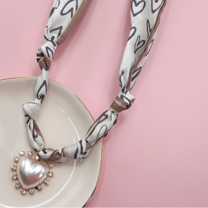 Necklace with heart-shaped pendant on a pink background