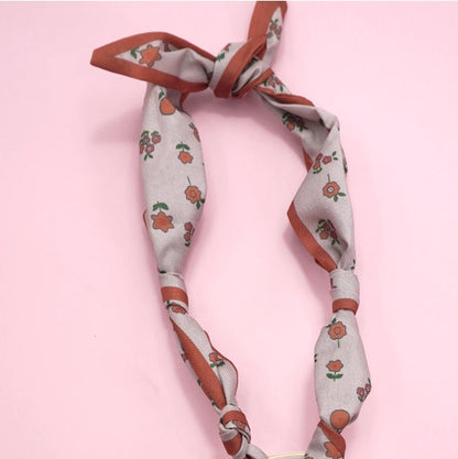 Decorative headband with floral pattern on a pink background