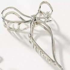 Silver bow-shaped hair claw on white background.