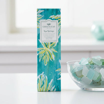 Greenleaf Spa Sprigs slim sachet on a white counter with a bowl of blue and green sea glass