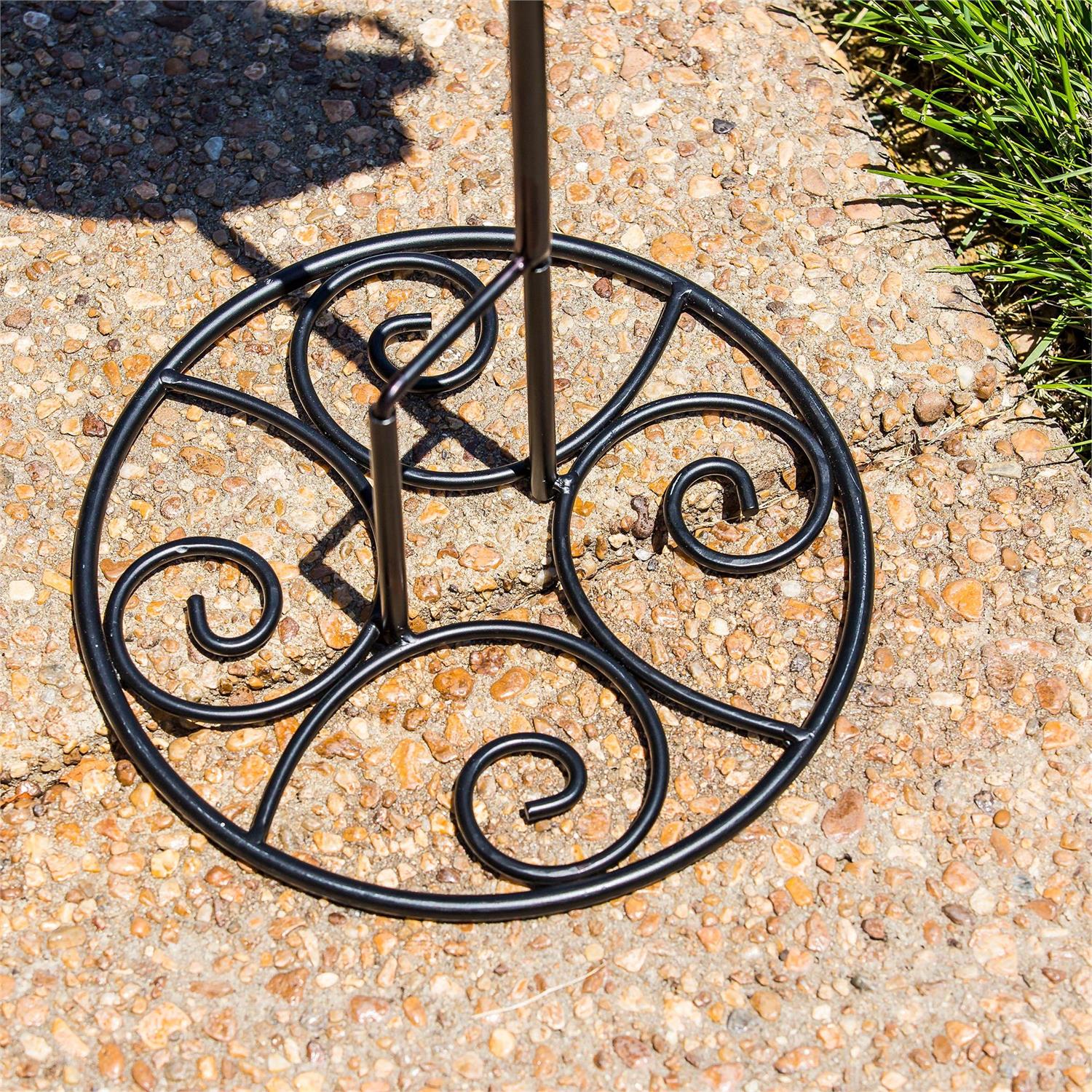 Elegant Swirl Flag Stand Base made of black metal on a pebbled surface.