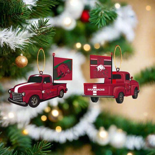 Red Arkansas Razorbacks truck Christmas ornaments on a decorated tree with lights and greenery.