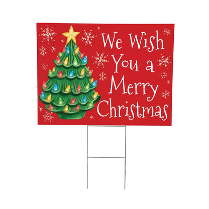 Christmas-themed yard sign with a decorated tree and 'We Wish You a Merry Christmas' text on a red background.
