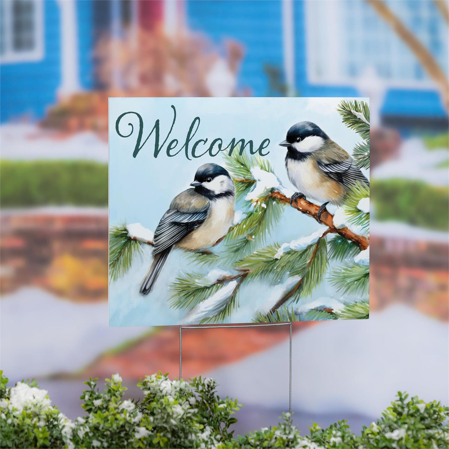 Decorative sign with two birds on a branch with 'Welcome' text, placed outdoors.