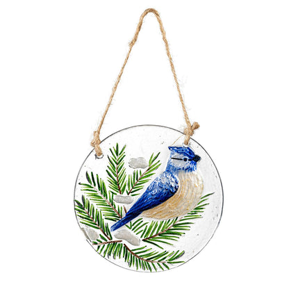 Decorative hanging disc with a blue jay and pine branch design on a white background
