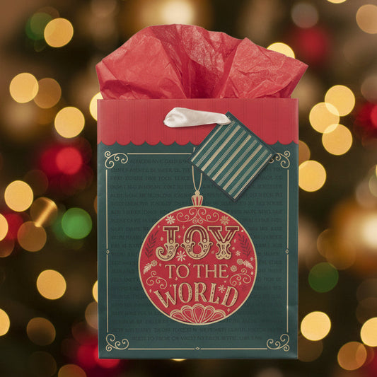 Red gift bag with 'Joy to the World' design against a festive blurred lights background