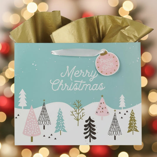 Christmas gift bag with festive trees design against a blurred Christmas lights background