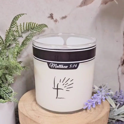 Video showing a candle being lit, revealing text saying "Be the Light" on the outside of the jar.
